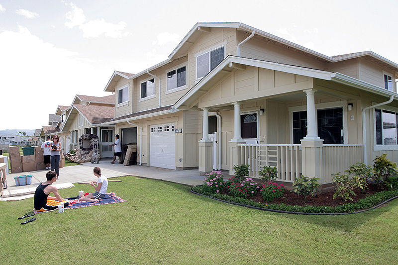 Navy_family_members_relax_on_their_front_lawn_while_movers_deliver_household_goods_to_their_new_home_on_Ford_Island